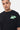 T-shirt June Noir Délavé en gros plan porté par un mannequin homme, cœur planète vert menthe brodé sur la poitrine