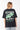 T-shirt June Noir Délavé oversize porté de dos par une mannequin, Create a Kinder Planet en blanc et vert, jean clair