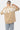 T-shirt Juno Beige oversize porté de dos par un mannequin homme, grand lettrage Eleven blanc, jean clair à fleurs de lys