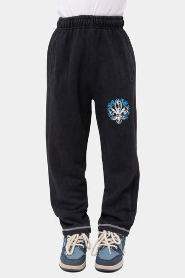 Jogging Jura Noir Délavé porté de face, écusson fleur de lys bleu et blanc sur la cuisse, bas de jambe à liseré gris