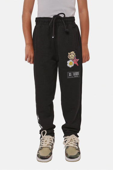 Jogging Fiston Noir porté par un enfant, vue de face avec écusson fleurs et étoile et étiquette Eleven Paris sur la cuisse