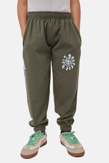 Jogging Foudre Kaki porté par un enfant, vue de face avec patch fleur smiley blanc sur la cuisse et baskets vertes