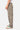 Pantalon Fiby Bandana Kaki large vu de profil, motif bandana noir sur fond kaki et baskets blanches à lacets verts