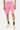 Short Ninon Rose porté par un homme, de face à mi-corps, chaussettes noires à coeur et baskets roses et crème