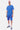 Short Ninon Bleu porté par un homme avec t-shirt bleu assorti et casquette, de face en pied, baskets bleues
