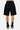 Short Palma Noir vu de dos sur un mannequin homme, coupe ample à bords francs, chaussettes noires et baskets