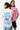 T-shirt Parma Écru porté par une mannequin femme de dos, inscription More amour por favor bleue, homme en rose derrière