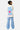 T-shirt Parma Écru vu de dos sur une mannequin femme, inscription More amour por favor bleue, pantalon rayé bleu