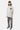 T-shirt Parma Gris délavé porté par un mannequin homme en casquette, coeur noir sur la poitrine, jean gris à croix