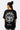 T-shirt Passau Noir porté par une mannequin femme de dos, grand emblème fleur de lys blanc et inscription New York