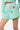 Short Jazeon Vert à rayures blanches, vue de face portée, poche et broderies main, fleur et coeur, étiquette Elevenparis