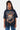 T-shirt Pharell Noir Délavé porté par une mannequin femme, vue de face, crâne en flammes et inscription Paname Crève Coeur