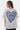 T-shirt Pinerolo Blanc porté par une mannequin femme aux tresses de dos, grand coeur souriant en damier bleu et noir