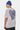 T-shirt Pinerolo Blanc porté par un mannequin homme en bonnet bleu, de trois quarts dos, grand coeur en damier bleu et noir