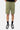 Short cargo Piranha Kaki porté par un mannequin homme, plan de face sur les poches à rabat, chaussettes noires et baskets
