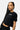 T-shirt court Plume Noir porté par une mannequin femme aux longues tresses, vue de trois quarts, inscription New York
