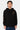 Sweat à capuche Poncho Noir porté par un mannequin homme en jean, de face, fleurs de lys léopard sur la poitrine et la manche