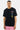 T-shirt Portofino Noir porté par un mannequin homme, de face, trois cœurs pastel sur la poitrine, short rose