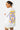 T-shirt Portofino Blanc porté par un mannequin femme, de dos, grand cœur violet et inscriptions Love Amor, short rayé jaune