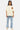 T-shirt Power Écru porté en pied par un mannequin femme, poche écusson terracotta, jean clair à motifs bleus