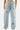 Jean Pretty Bleu Clair porté par un mannequin femme, vu de dos et de près, poches arrière et fleurs de lys bleues et blanches