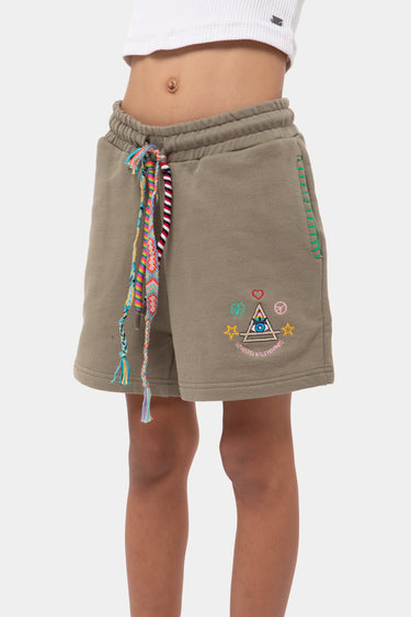 Short Puntacana Kaki porté par un enfant, cordon tressé multicolore et écusson brodé en forme de triangle sur la jambe