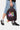 Sac à dos Job Noir tenu à la main, grande fleur smiley multicolore sur la poche avant et porte-clé fleur