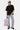 Sac à dos Jalley Bandana Rose tenu à la main par un mannequin femme en pied, t-shirt noir, jean clair et baskets