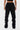 Pantalon cargo Suede Noir porté vu de dos, poches à rabat et petit coeur brodé, bas de jambe évasé