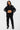 Pantalon cargo Suede Noir porté en pied par une mannequin femme avec sweat zippé noir à manches brodées