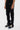 Pantalon cargo Suede Noir porté de trois quarts, poches latérales à rabat, baskets noires et lacets crème