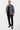 Pantalon cargo Suede Noir porté en pied par un mannequin homme avec chemise rayée grise ouverte