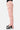 Pantalon cargo Suede Rose porté de profil, poche cargo latérale et jambe évasée, baskets noires et blanches