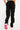 Pantalon cargo Suede blk noir porté vu de dos, poches à rabat, jambe fendue et baskets blanches et roses
