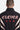 Veste zippée Taren Noir en gros plan de dos, inscription ELEVEN gothique blanche et fleurs de lys rouges