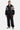 Veste zippée Taren Noir portée en pied par un mannequin homme avec jogging noir assorti et baskets grises