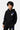 Sweat à capuche enfant Tfila Noir porté par un garçon, de face, fleurs de lys blanche et violette sur la poitrine