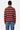 Pull polo Thomas Rouge en maille rayée porté par une femme, de dos, rayures rouges et roses, jean bleu à fleurs de lys