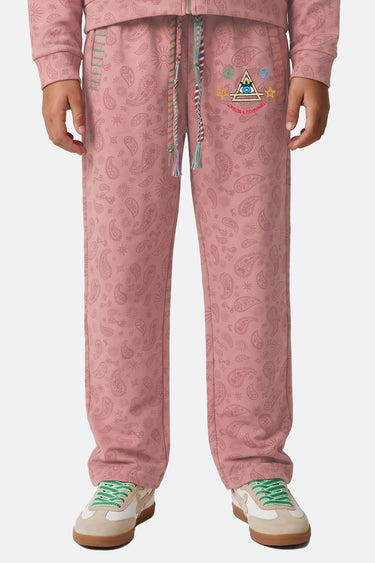 Jogging Tika Rose Bandana porté de face, cordon tressé multicolore, écusson brodé et baskets blanches