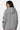 Sweat à capuche zippé Tindra Gris Chiné porté de dos par une femme, écussons No Switch sur les manches