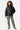 Doudoune Toupie Black noir brillant en look complet portée par une fille avec pantalon zébré et baskets