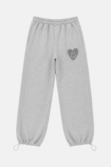 Jogging Tulum Gris Chiné de face à plat, cœur smiley gris foncé sur la cuisse et cordons de serrage aux chevilles