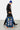 Valise Fugers Bleu Marine M tenue par un homme en bonnet bleu et sweat noir, patchs colorés, roulettes orange
