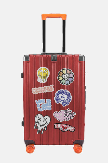 Valise Fugers Rouge M de face, coque rouge ornée de patchs colorés, poignée et roulettes orange