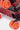 Valise Fugers Rouge M, zoom sur les roulettes orange Eleven Paris et le bas de coque rouge à rivets
