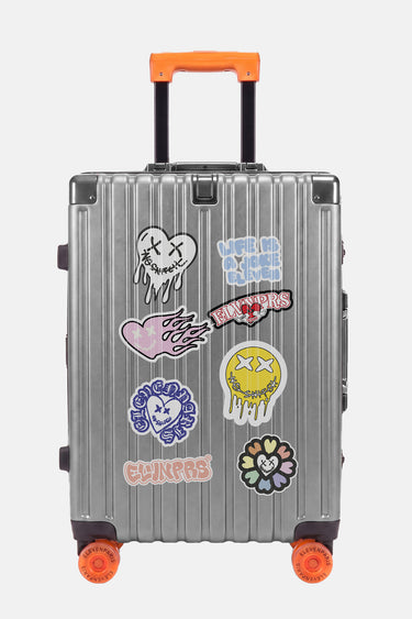 Valise Fugers Argent S de face, coque gris argenté avec patchs colorés, poignée et roulettes orange