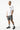 Maillot de bain short Jamaique Kaki à motif gris, porté en pied par un mannequin homme avec t-shirt blanc et baskets noires