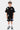 Short Jonah Noir porté par un garçon avec t-shirt noir assorti, écussons colorés Elvn et No Snitch, vue de face en pied