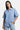 Chemise Jovenis Bleu à manches courtes portée par une mannequin femme, de face, main dans la poche du jean