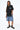 T-shirt Lys Noir delavé porté par une mannequin femme avec bermuda en jean à fleurs de lys, vue de face en pied